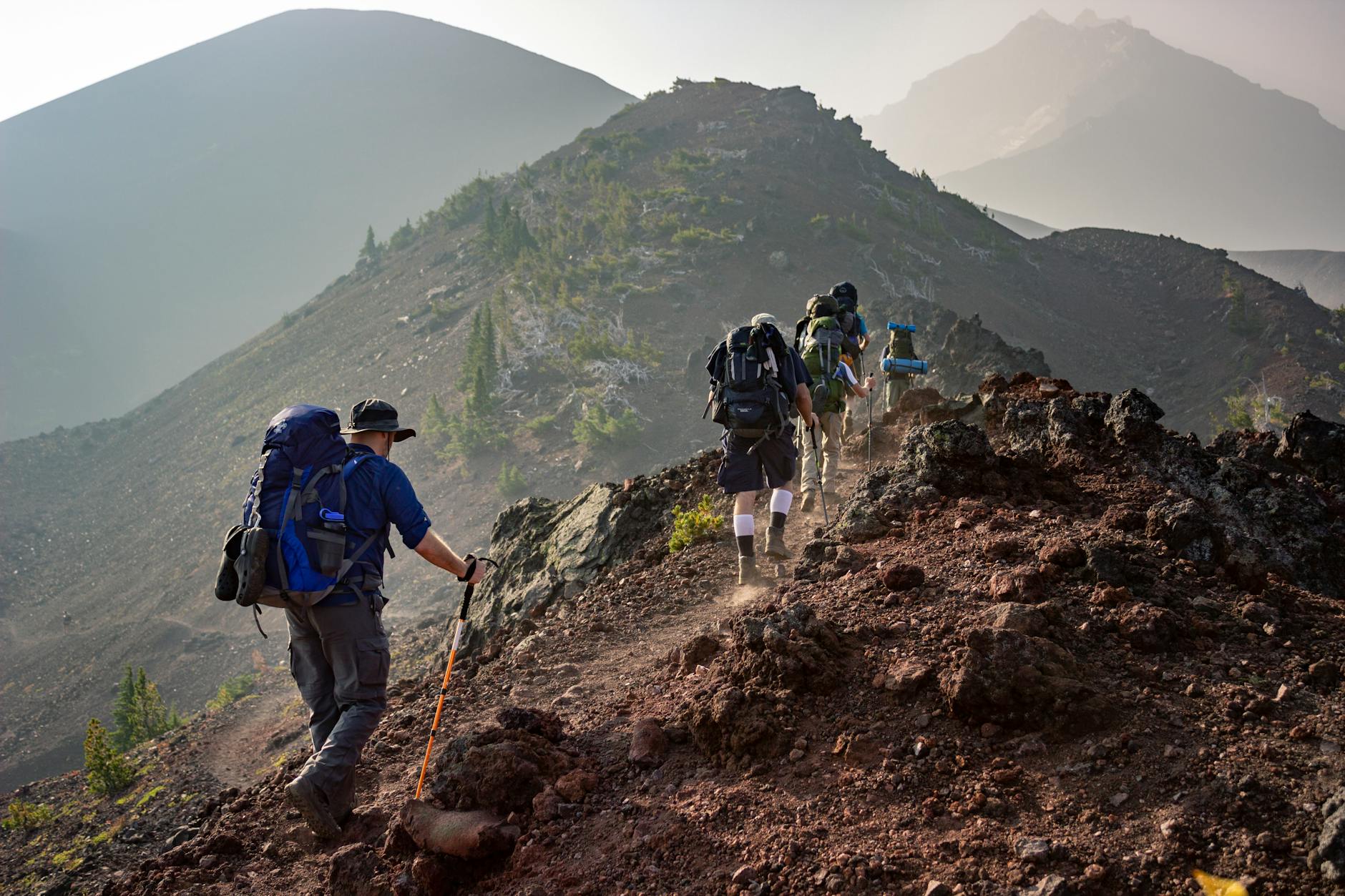 grupo de pessoas caminhando subindo uma montanha