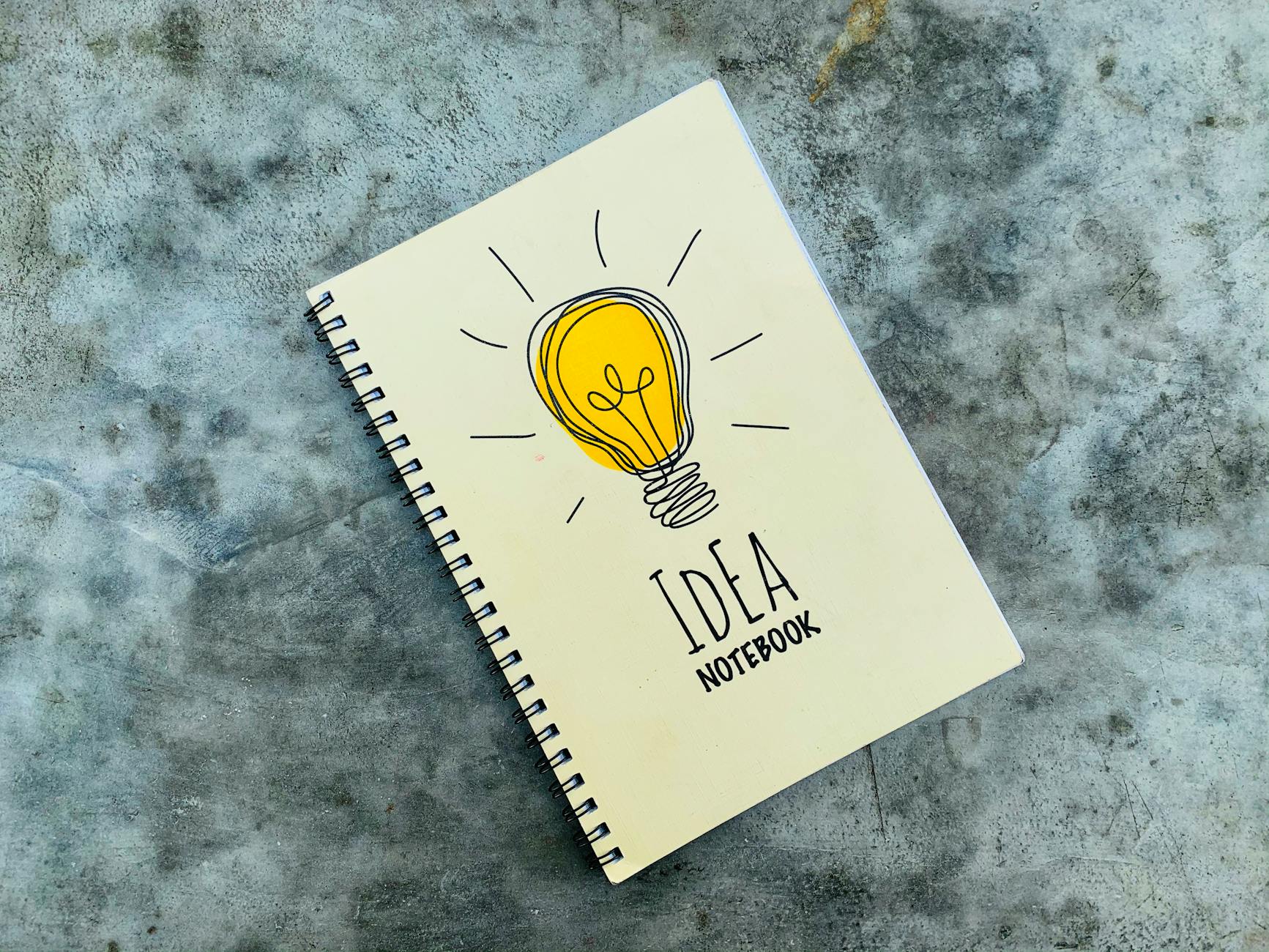 imagem de uma lâmpada incandescente na capa de um caderno para anotar ideias